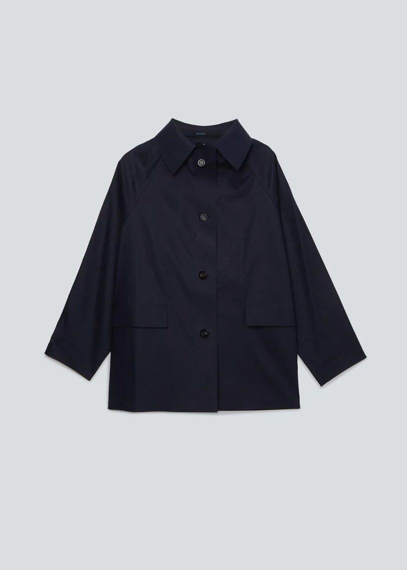 Ghost-mannequin packshot of a navy button-up jacket with raglan sleeves and patch pockets on a pale background