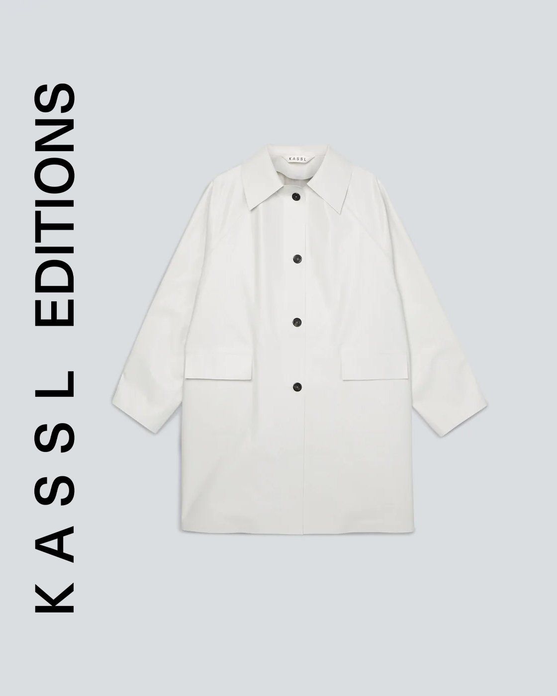 White button-front coat with collar on pale grey background, Kassl Editions flat lay