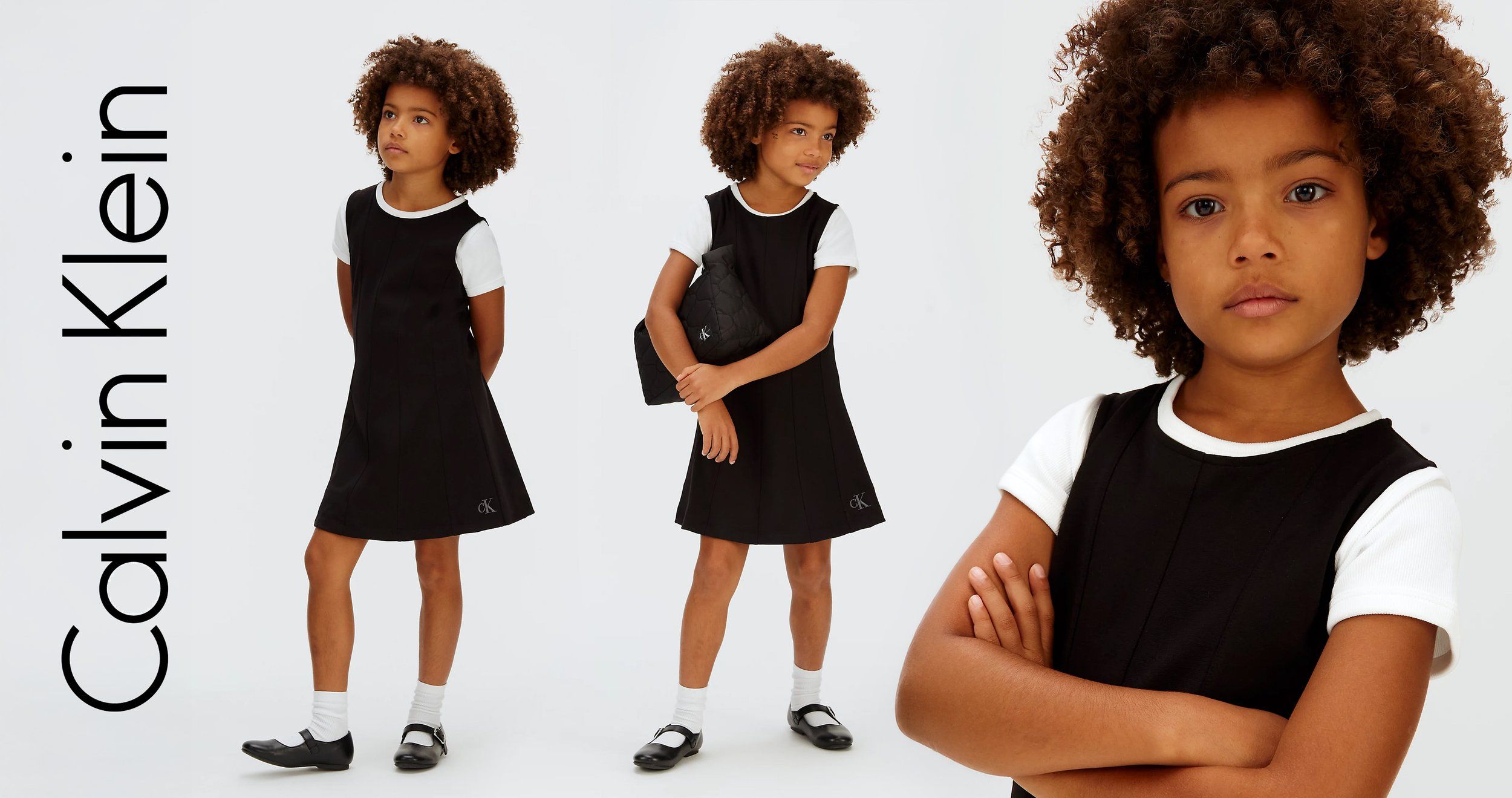Calvin Klein logo beside a child model in a black pinafore dress with white sleeves, full-length and close-up views