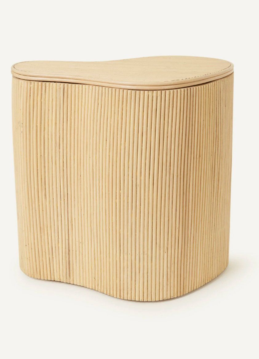 Natural rattan storage box with organic curved shape and fluted lid on a light neutral background
